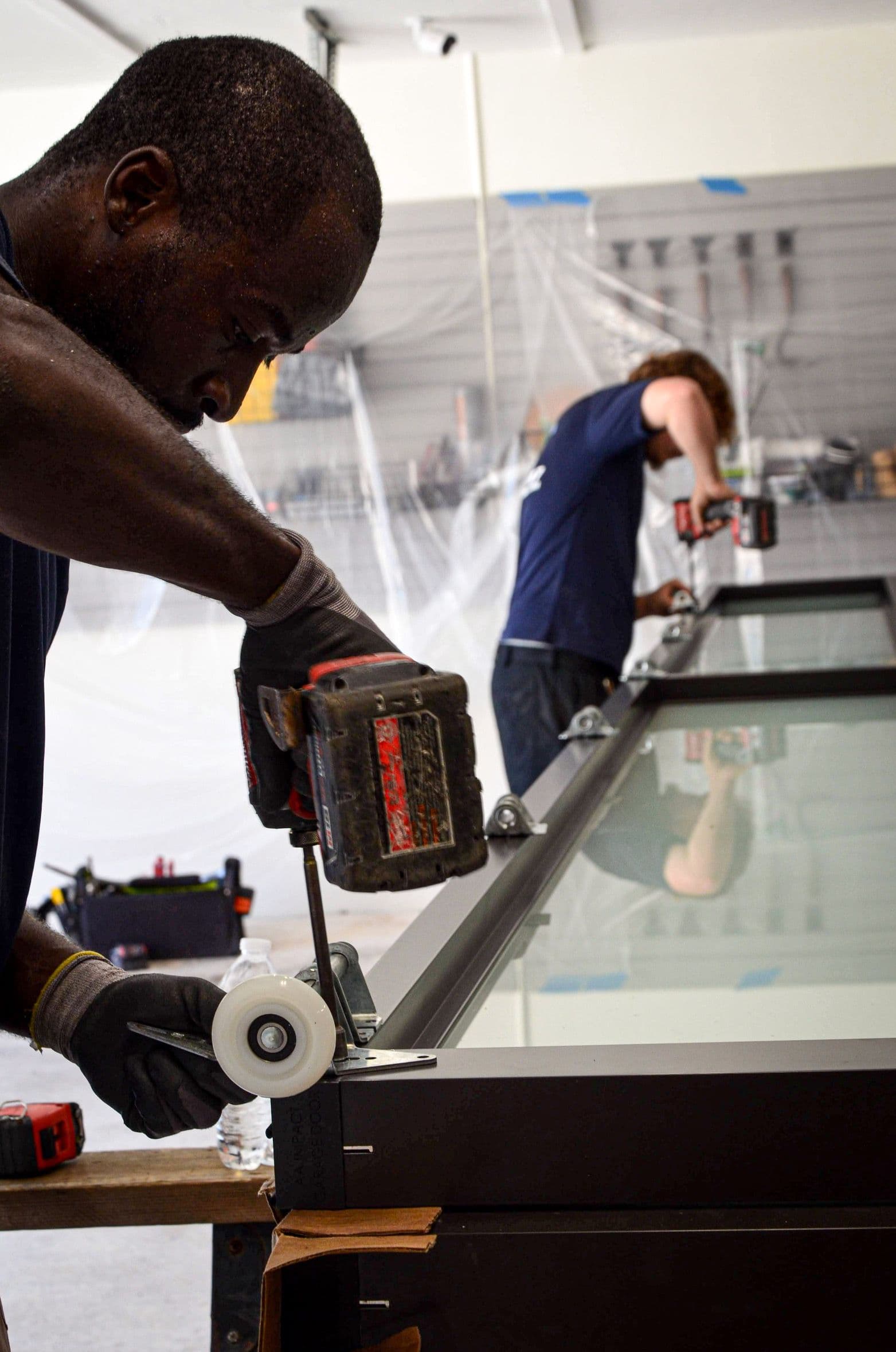 Team Member Drilling Garage Door Roller